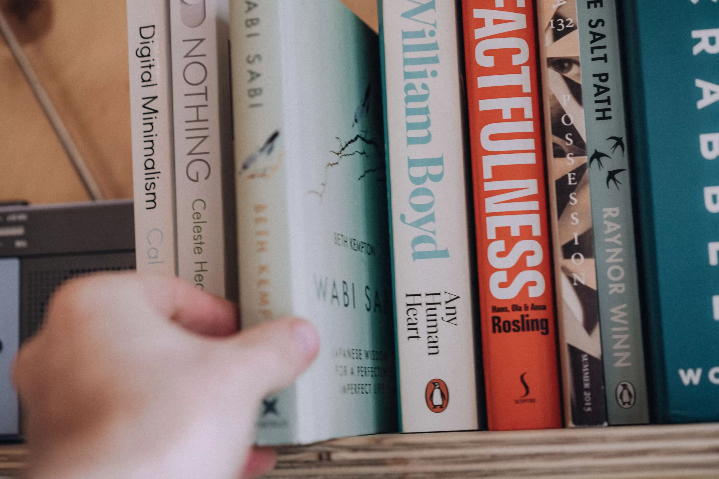 A man selecting a book from a bookshelf