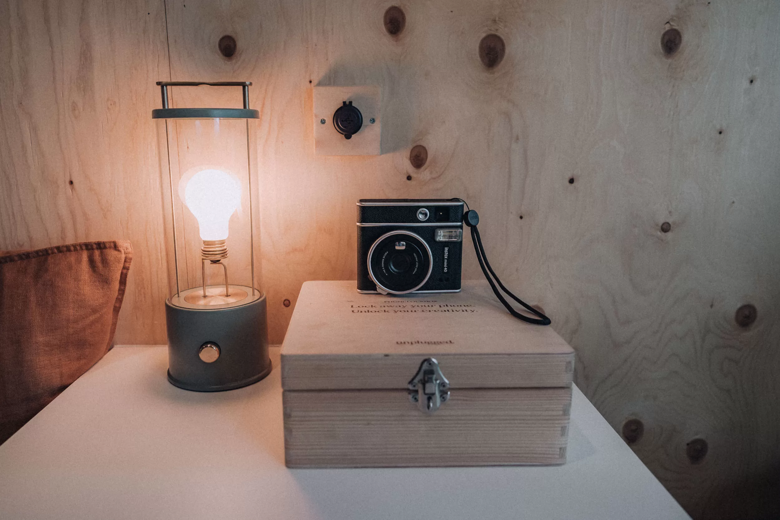 A lamp and camera on a wooden table