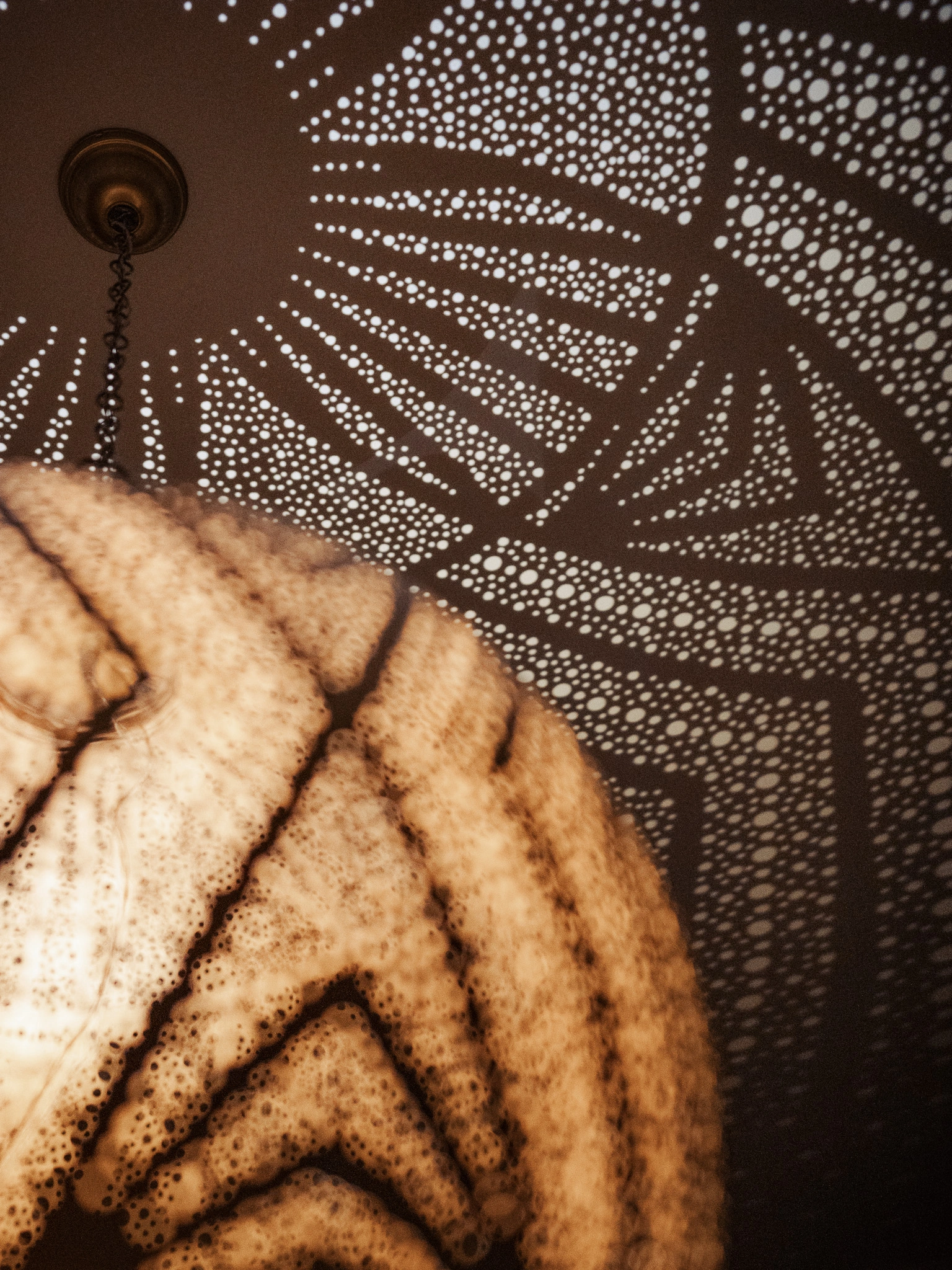 Bedroom lantern casting patterned shadows across the ceiling at Four Seasons Marrakech