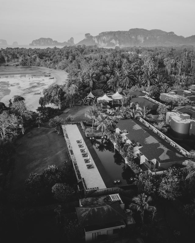 aA hotel and swimming pool complex with a sandy beach cove.
