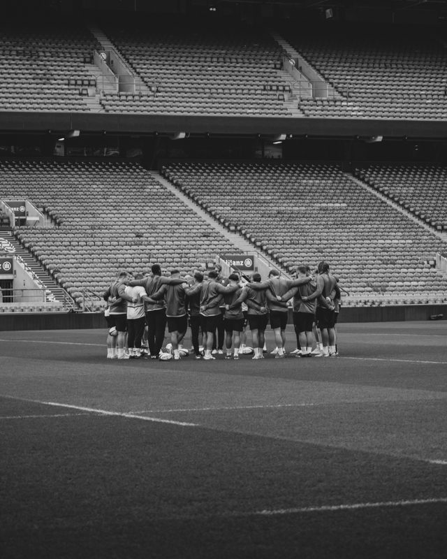 A team of rugby players huddle before practice.