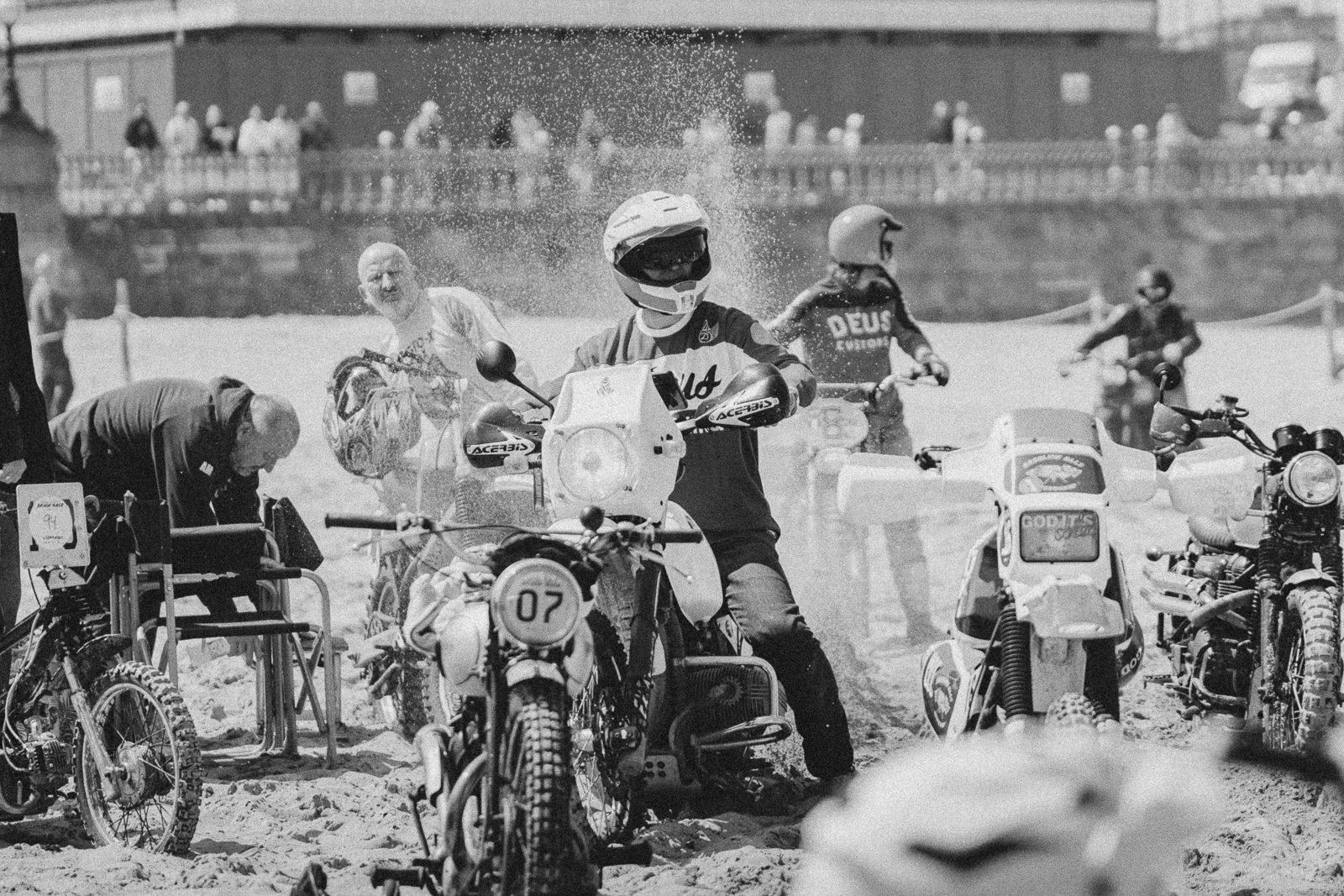 Motorcycles and thir riders waiting at the starting line.