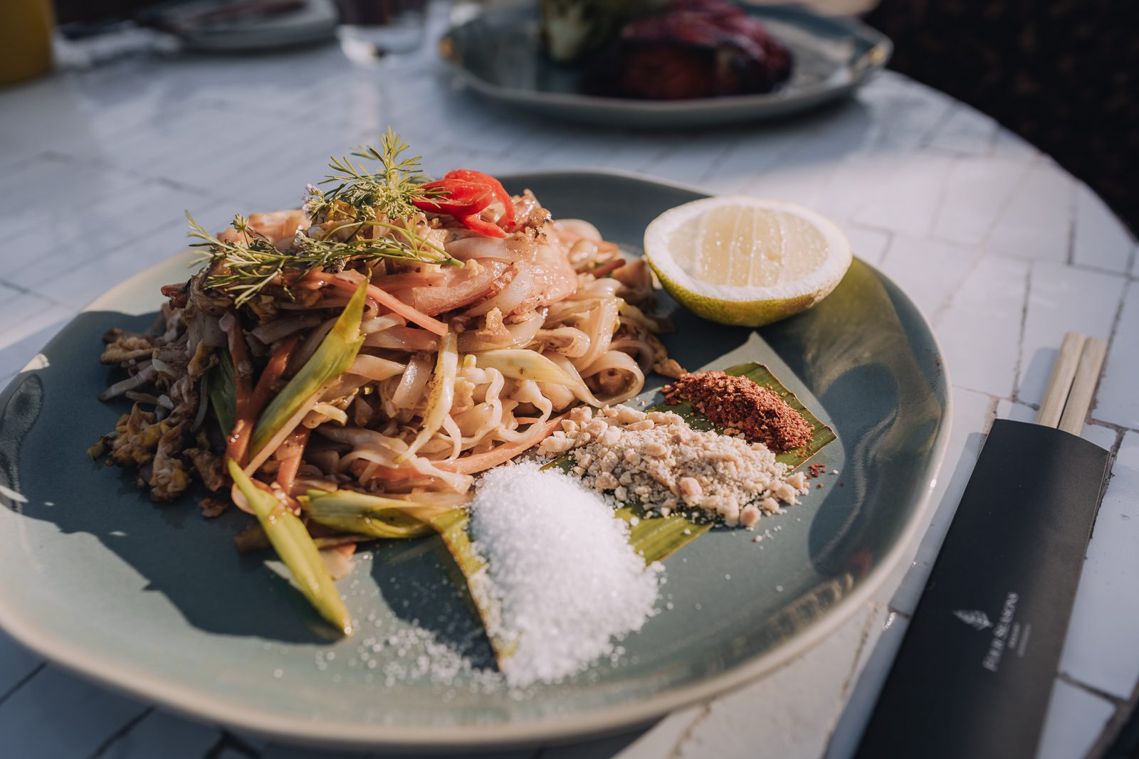 Noodles garnished with herbs and lemon