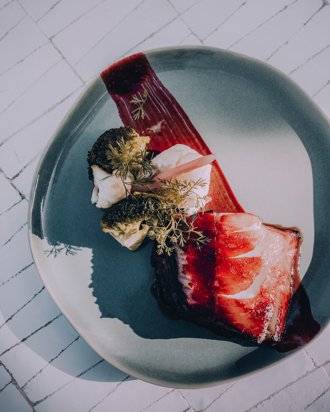 Elegant plate with baked cod and broccoli.