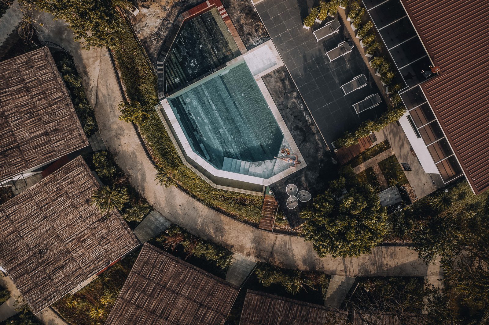 Woman relaxing beside a aqua pool.