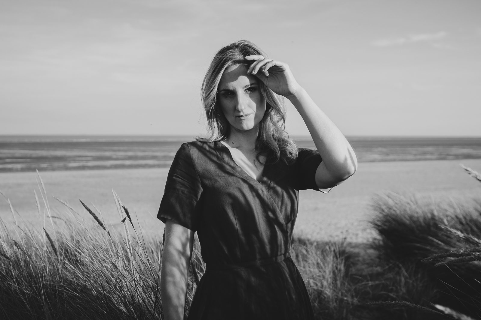Woman standing on beach, serene atmosphere.
