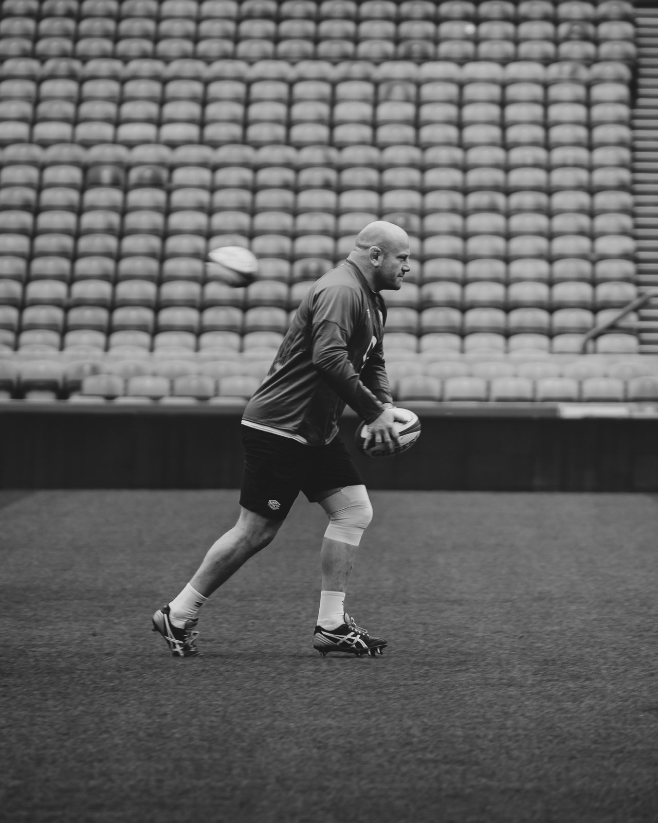 England Rugby team player runs while holding a rugby ball.