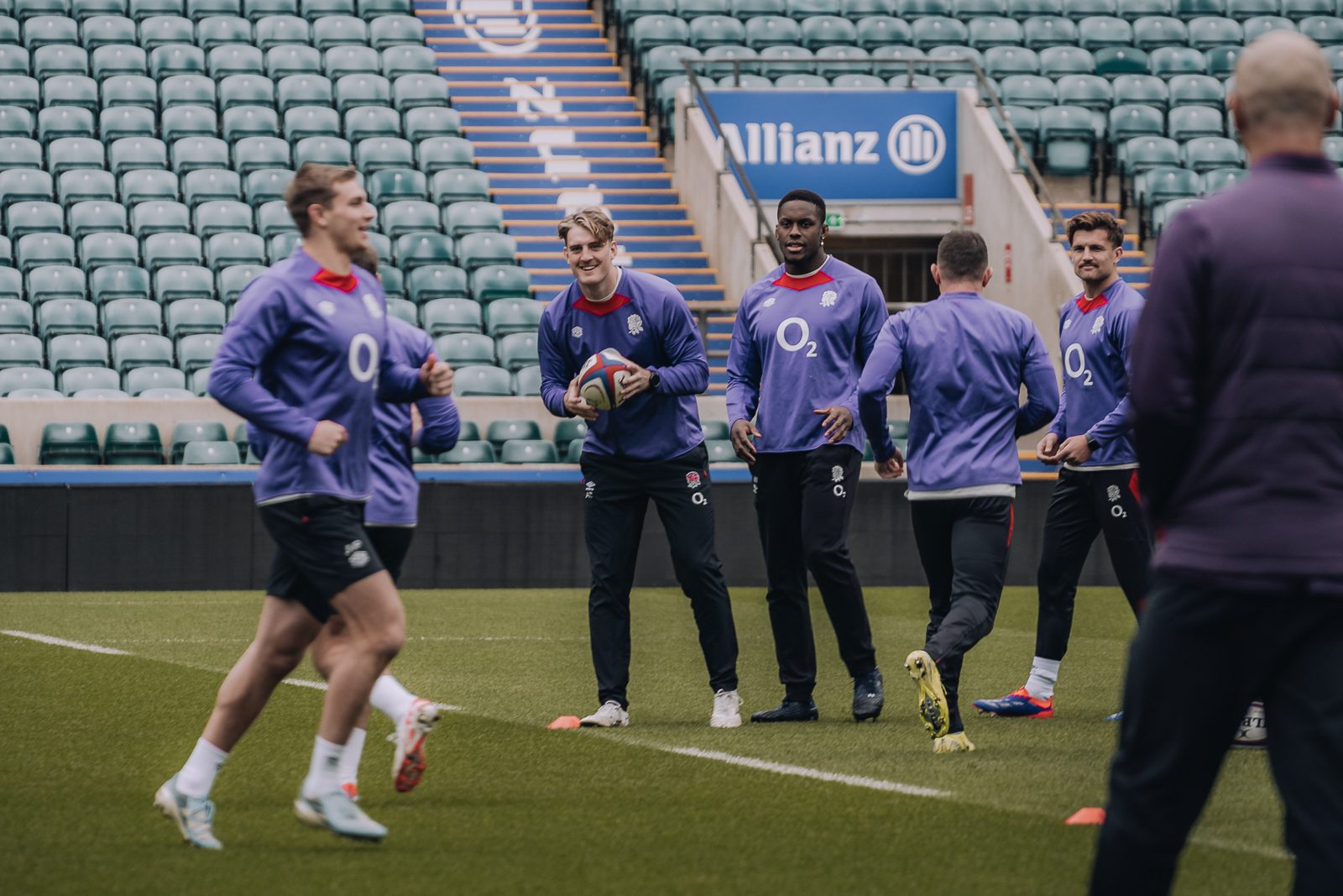 Rugby players practice in a stadium.