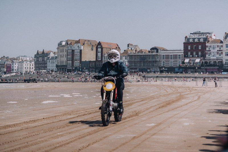 A motorcyclist rides his bike along a sandy beach in Margate.