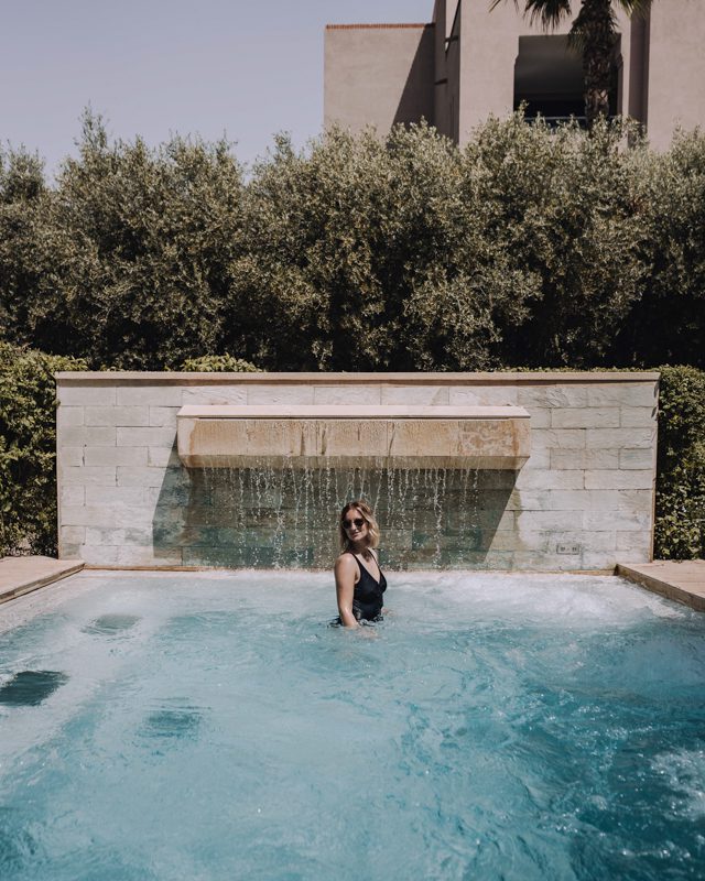Woman poses in outdoor jacuzzi pool in Marrakech.