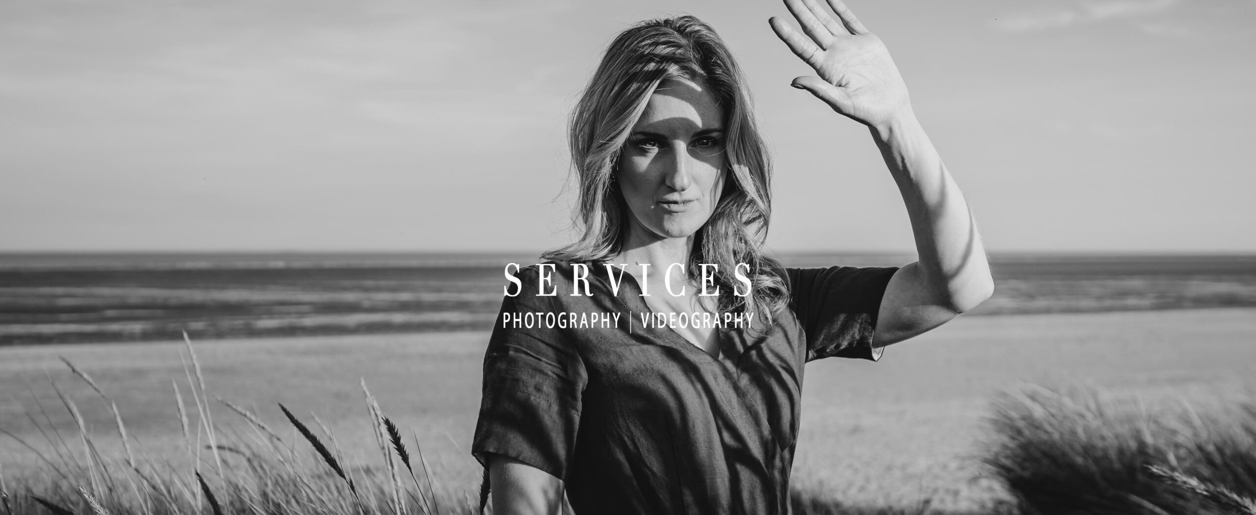 Black and white image of a woman on a sandy beach.