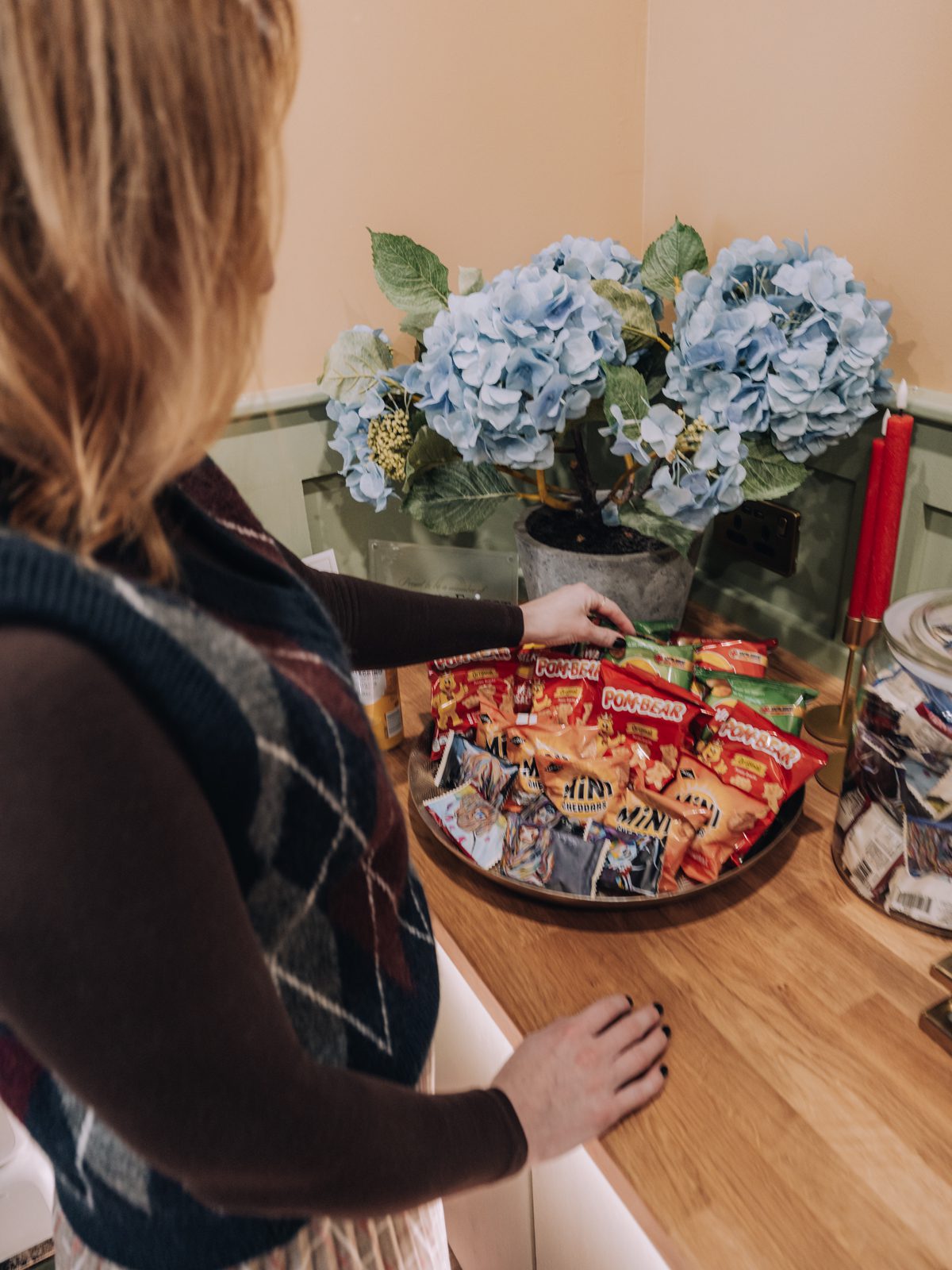 Woman selecting snacks from tray.