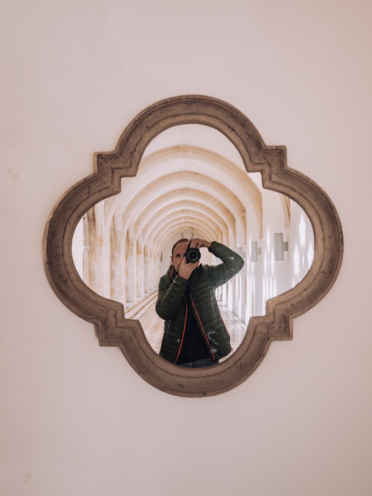 male photographer in reflection in ornate mirror