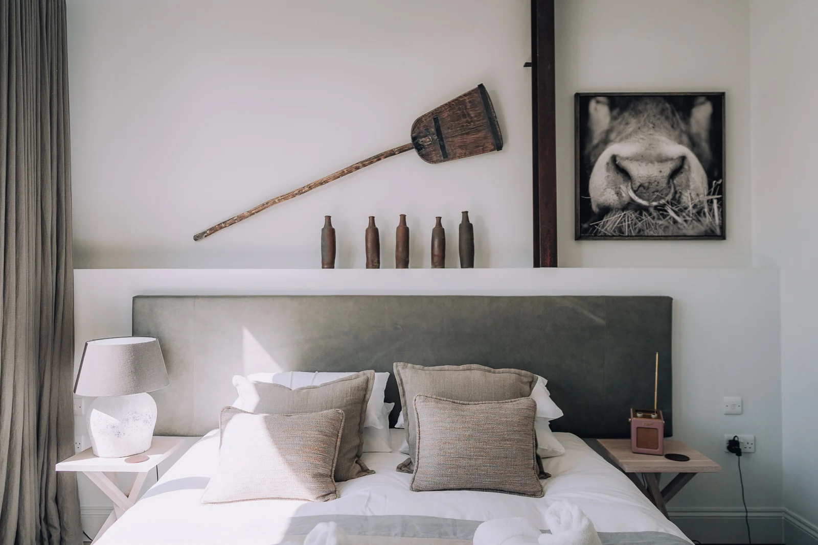 Bed and artwork on the walls inside the Bull Pen at Bibury Farm Barns