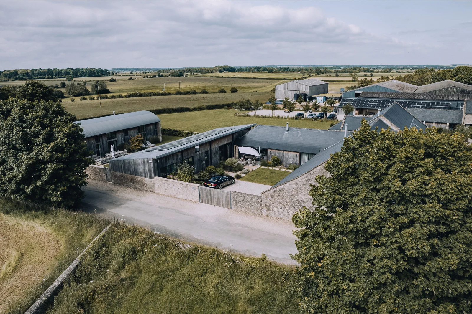 Aerial view of Bibury Farm Barns and the surrounding Cotswolds countryside