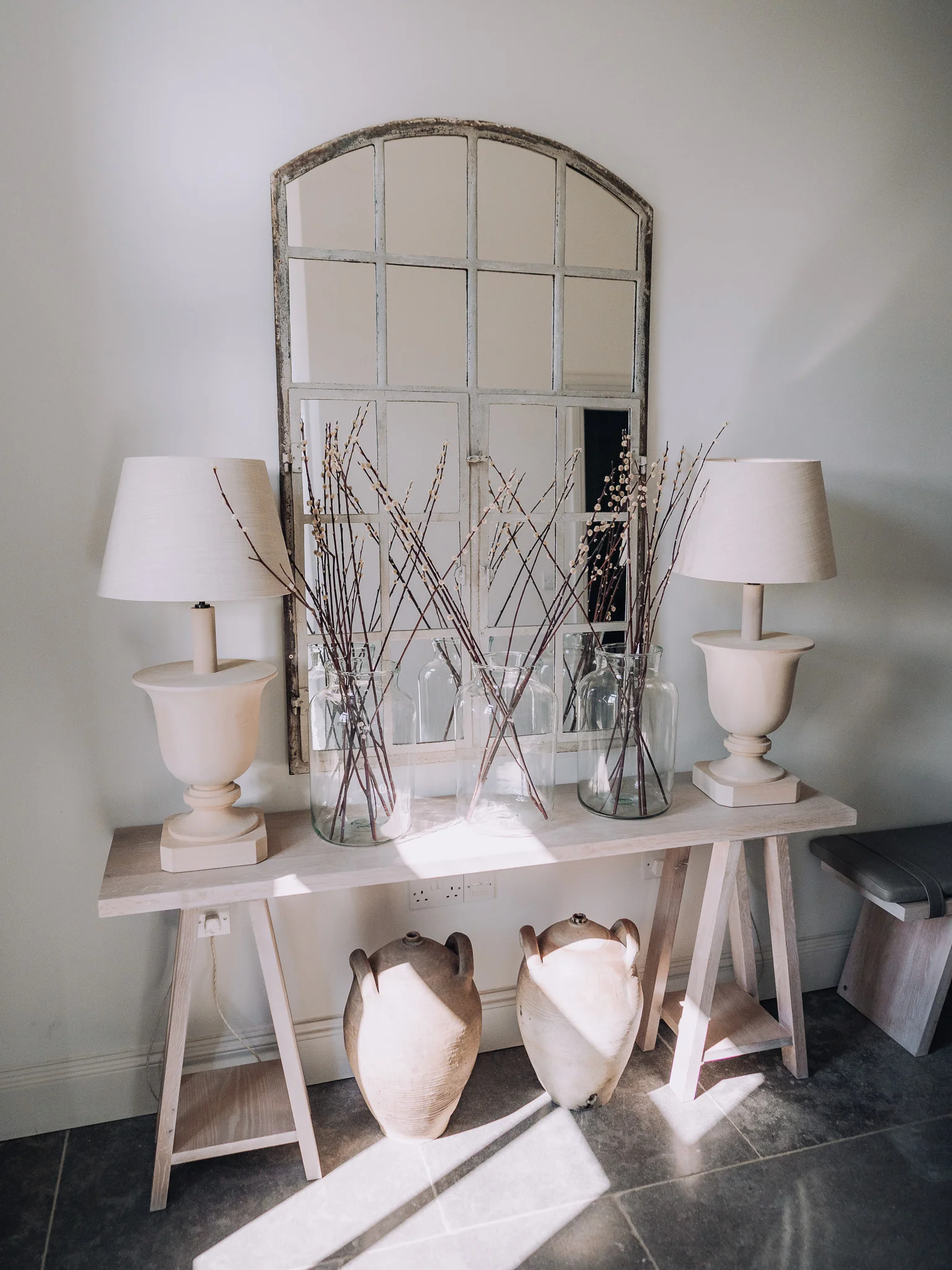 Light and shadow in the hallway with a centre table and decor at Bibury Farm Barns